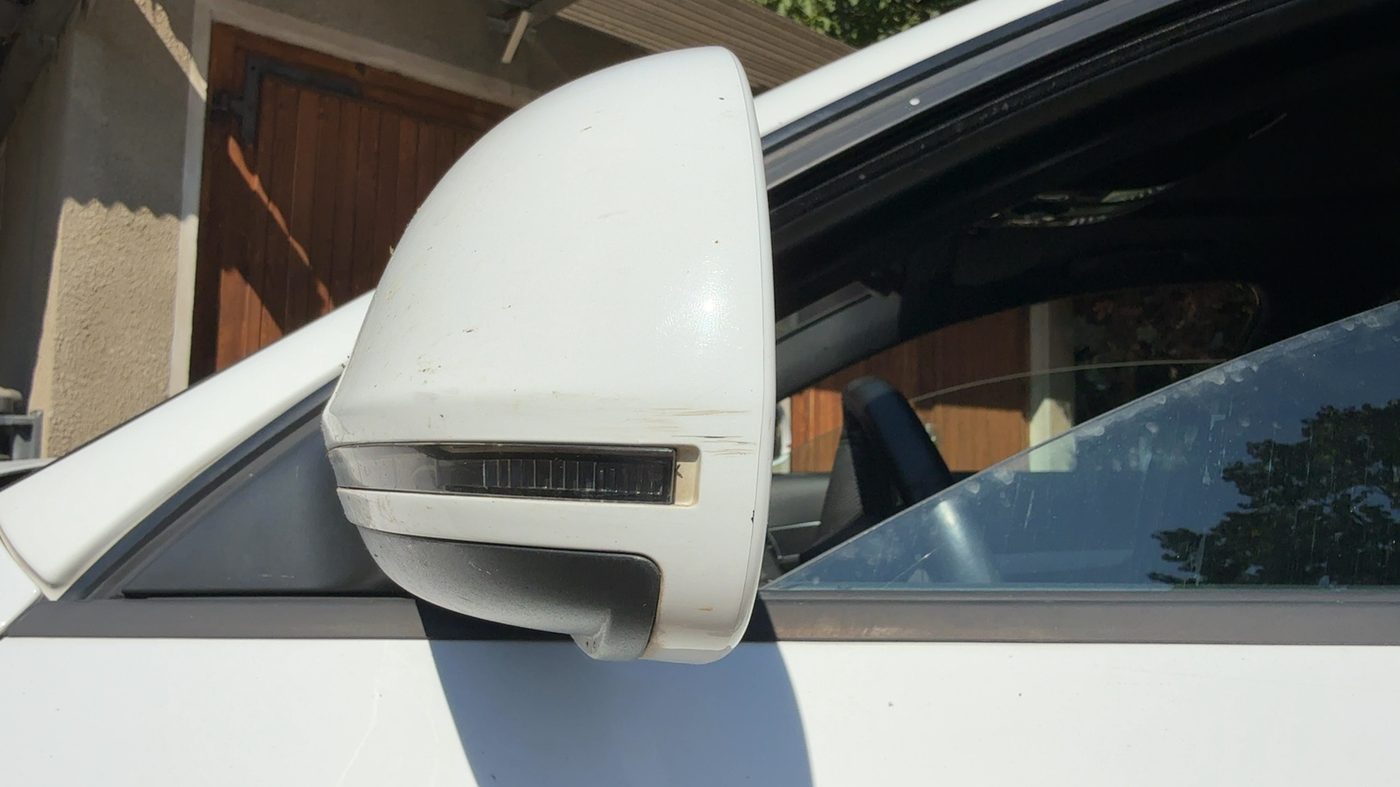 Aufgerissene Verkleidung an einem Unfallfahrzeug, dahinter liegen Träger und Steckkontakte frei